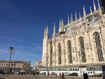 Tourists in front of building against clear sky