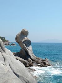 Scenic view of sea and rock formations against clear sky