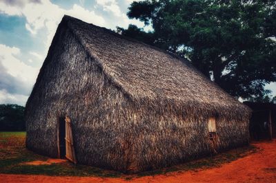 View of cottage on field against sky