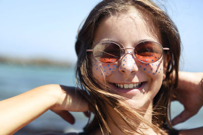 Close-up portrait of young woman wearing sunglasses