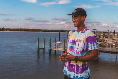 Happy boy standing in water against sky