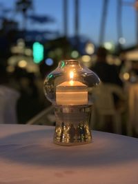 Close-up of illuminated glass jar on table at restaurant