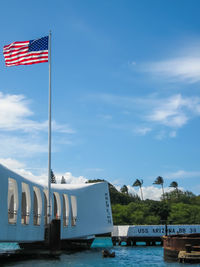Flag on boat against blue sky