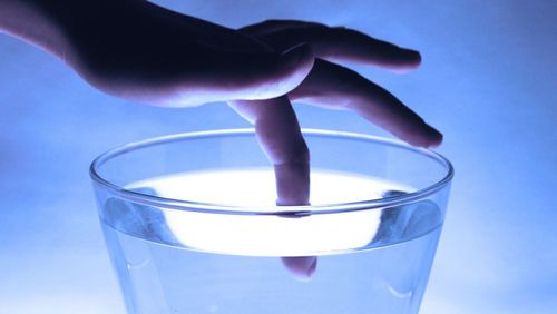 Close-up of blue glass against white background