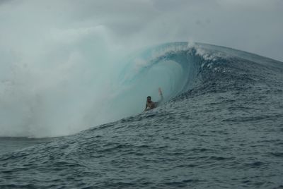 Man surfing in sea against sky