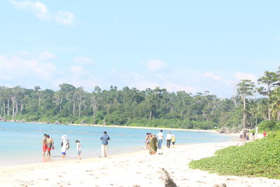 People at beach against sky