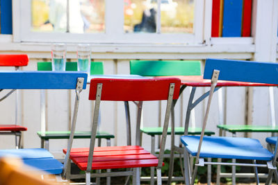 Empty colorful chairs arranged by table