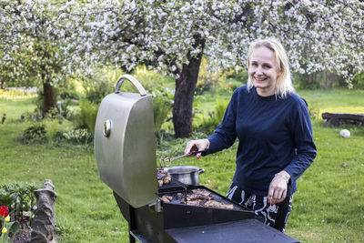 Woman making barbecue at backyard