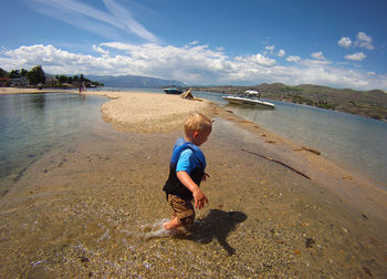 Silhouette of child walking in water on beach