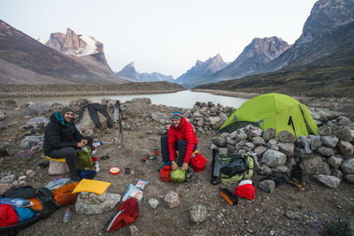 Two climbers at summit lake basecamp in akshayak pass, baffin island.