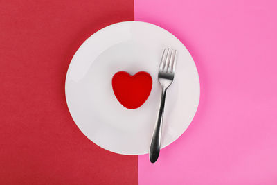 Directly above shot of heart shape on red table