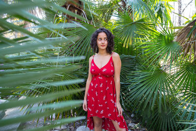 Young woman standing against trees