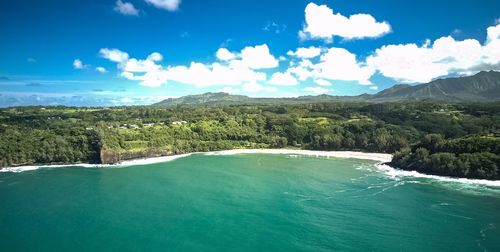 Scenic view of sea and mountains against blue sky