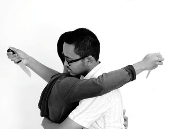 Full length of man with arms raised against white background