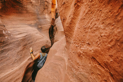 Young man exploring narrow slot canyons in escalante, during summer