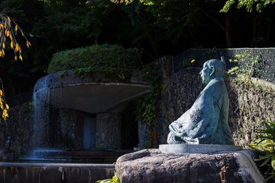 Statue by trees against plants