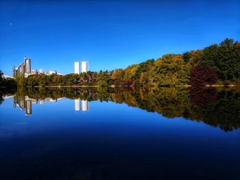 Reflection of trees in lake against blue sky