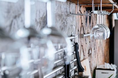 Close-up of wineglasses hanging against wall