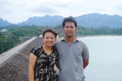 Portrait of smiling young man against mountains