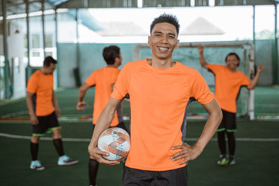 Portrait of young man playing soccer at gym
