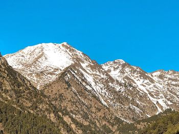 Scenic view of snowcapped mountains against clear blue sky