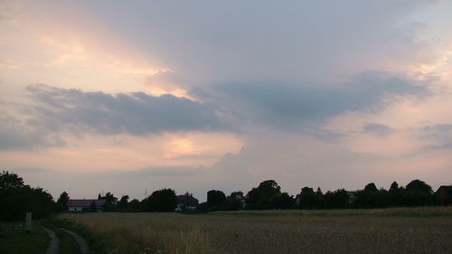 Scenic view of field against cloudy sky