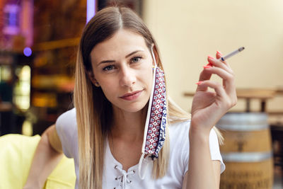 Portrait of young woman holding camera