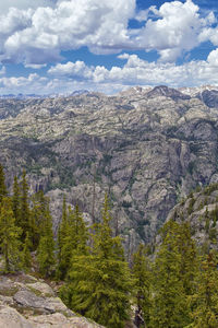 Scenic view of trees and mountains against sky