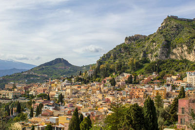 Aerial view of townscape and mountains against sky