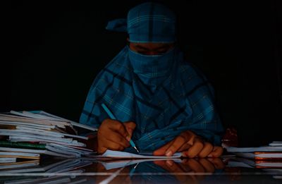 Man working on table against black background