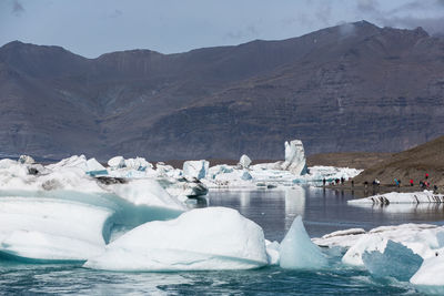 Scenic view of frozen lake against mountain range