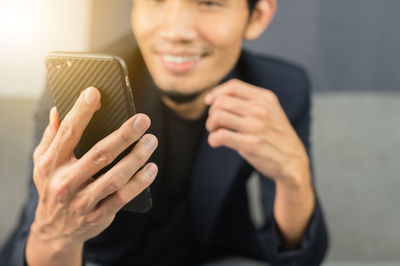 Midsection of man using mobile phone