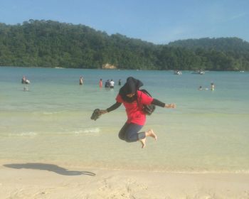 Boy on beach against sky