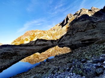 Low angle view of rocks on mountain against sky