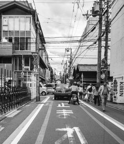 People on street in city against sky