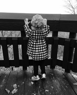 Full length of woman standing by railing