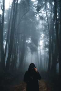 Man standing in forest against trees