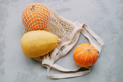 Mesh shopping bag with vegetables. autumn pumpkin harvest