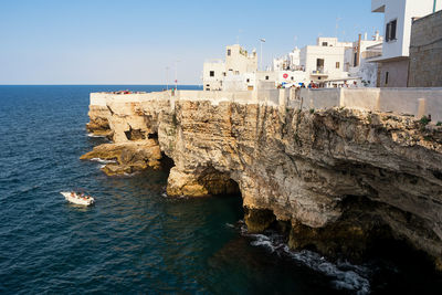 Scenic view of sea by buildings against sky