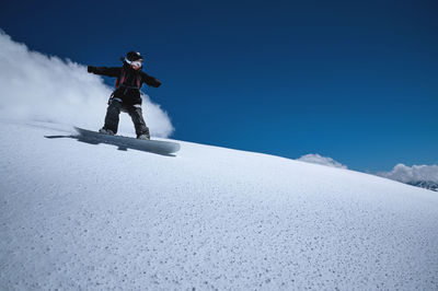 Man skiing on snowcapped mountain against sky