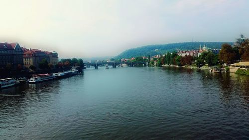 River amidst buildings in city against sky