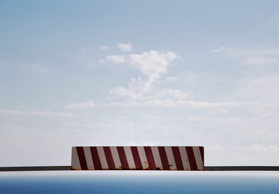 Road sign on metal against blue sky