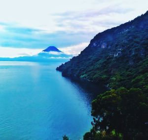 Scenic view of sea and mountains against sky