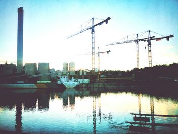 Silhouette of cranes at harbor