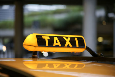 Close-up of yellow sign on car