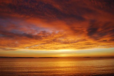 Scenic view of sea against dramatic sky during sunset