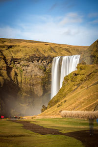 Scenic view of skogafoss waterfall against sky