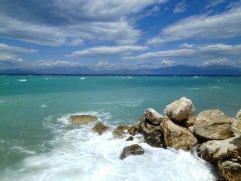 View of calm blue sea against cloudy sky