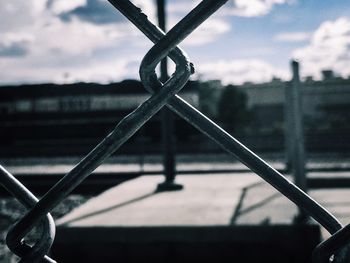 Close-up of chainlink fence against sky