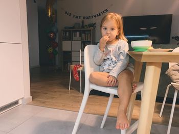 Young woman sitting on chair at home